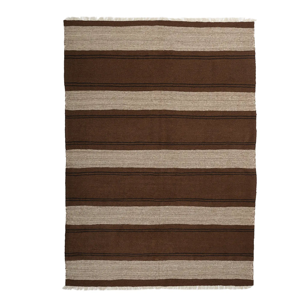Striped brown and beige rug on a white background